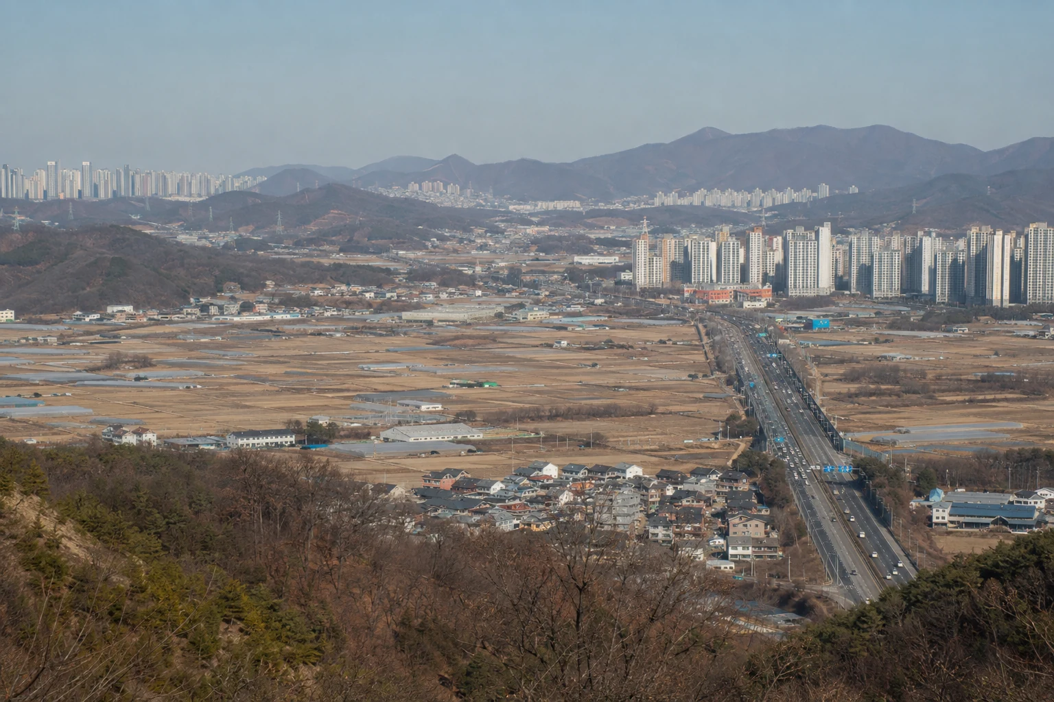 농지와 저층 주거지, 공동주택과 간선도로가 넓은 지역 안에 함께 보이는 도시 외곽