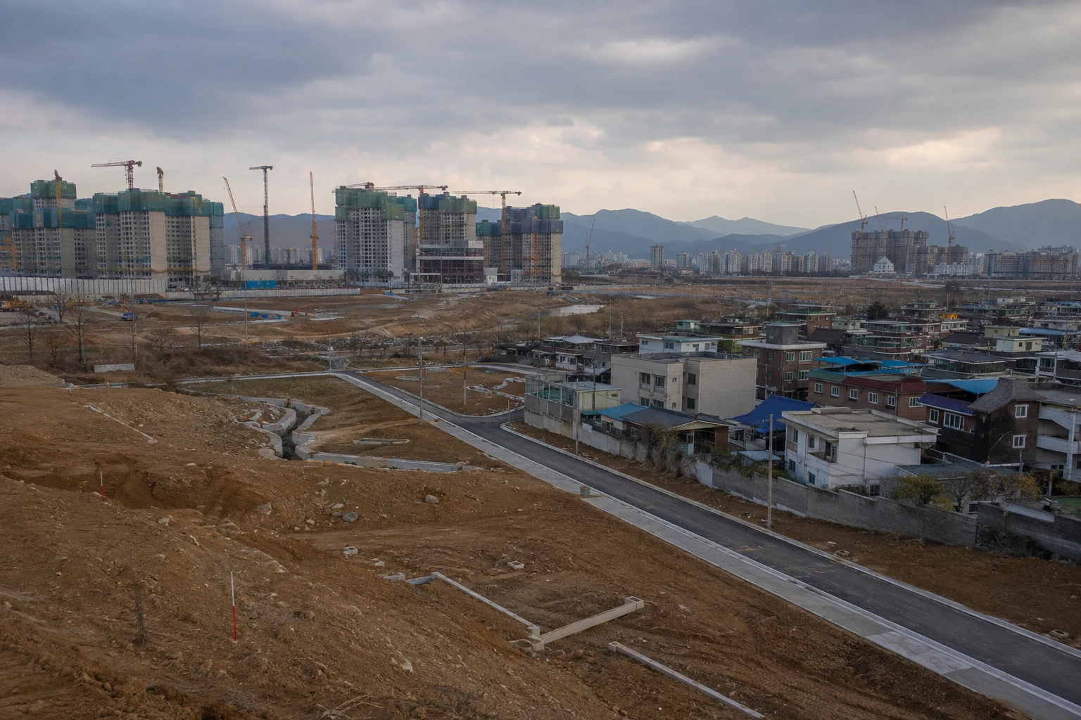 공공주택지구 조성지와 기존 주거지, 도로와 공동주택 공사가 함께 보이는 전경