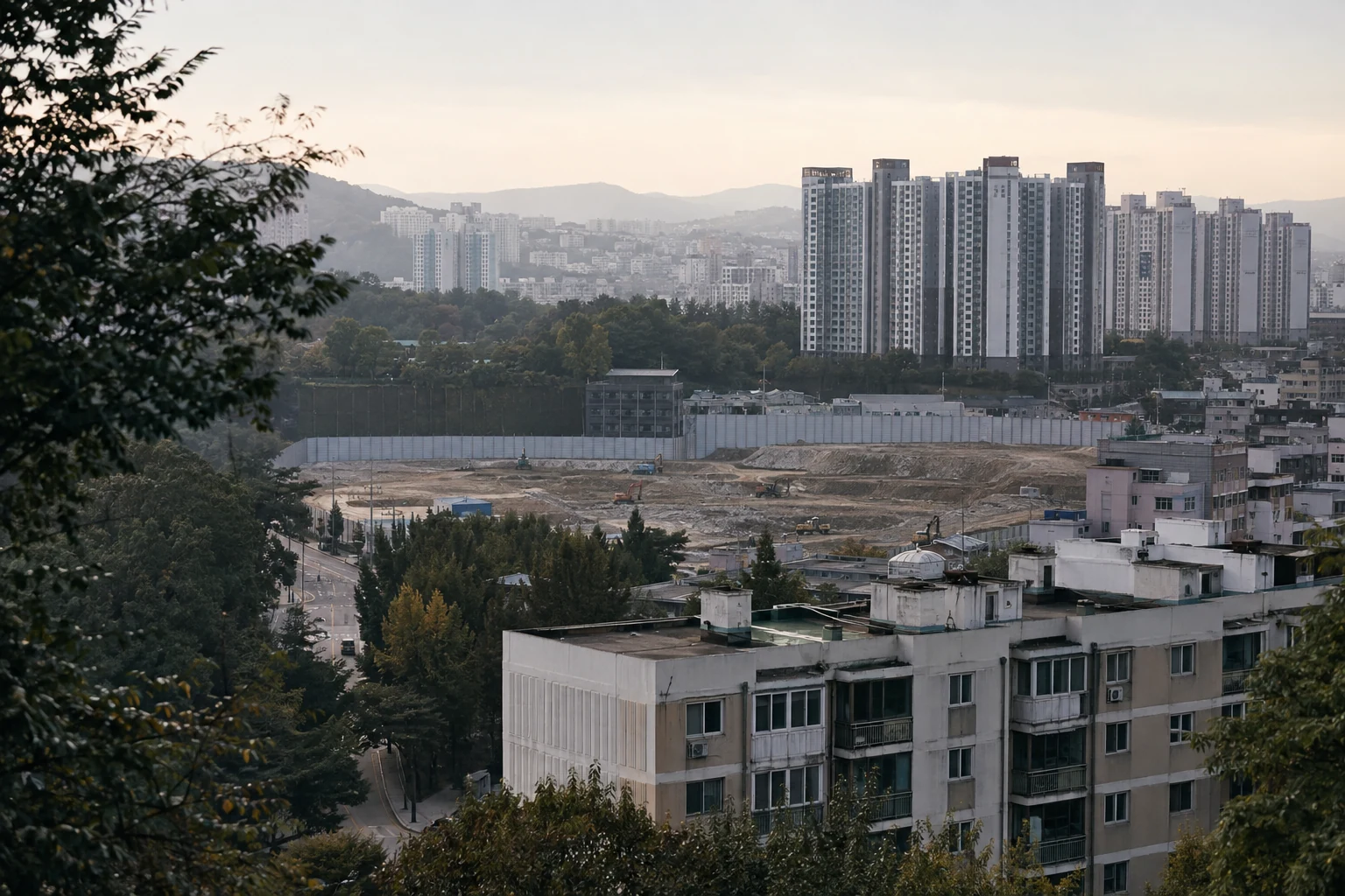 기존 공동주택과 정비 준비 구간, 신축 공동주택이 여러 단계로 보이는 도시 전경