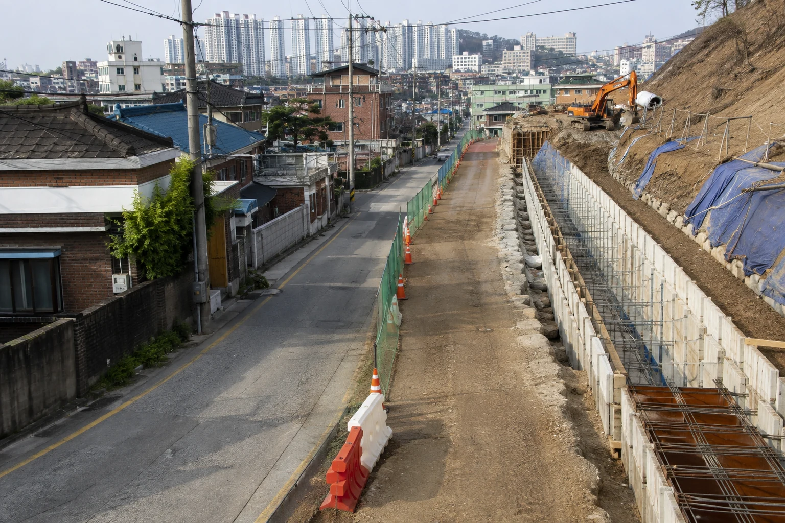 기존 도로와 측량·정비 구간, 옹벽 공사가 단계적으로 이어지는 도시계획시설 현장